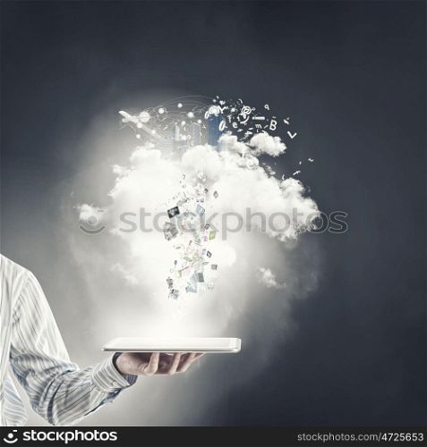 Technologies in use. Close up of hand holding tablet pc and icons flying in air