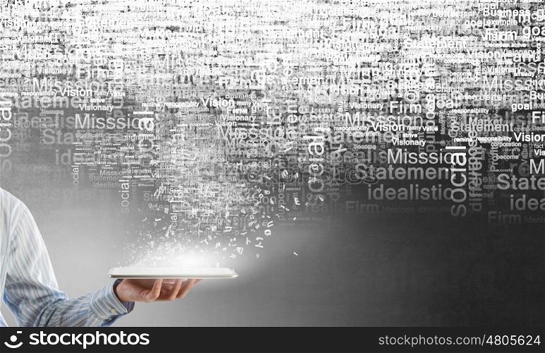 Technologies in use. Close up of hand holding tablet pc and words in air