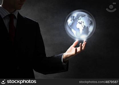 Technologies that connect the world. Hand of businessman showing digital earth globe