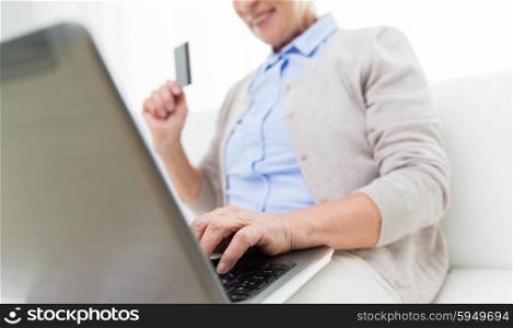 technology, age and people concept - close up of happy senior woman with laptop compute and credit or bank card r at home