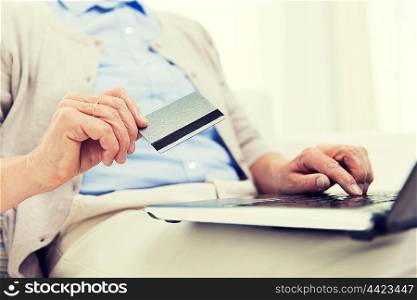 technology, age and people concept - close up of senior woman with laptop compute and credit or bank card r at home