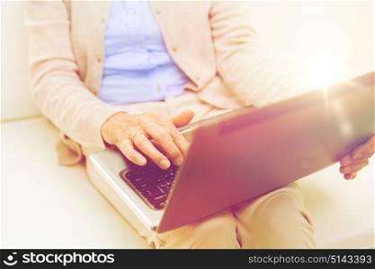 technology, age and people concept - close up of senior woman with laptop computer at home. close up of senior woman with laptop at home