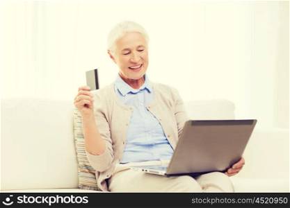 technology, age and people concept - happy senior woman with laptop compute and credit or bank card r at home