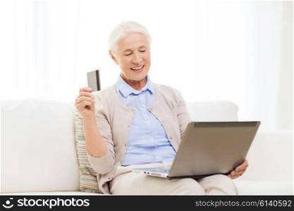technology, age and people concept - happy senior woman with laptop compute and credit or bank card r at home