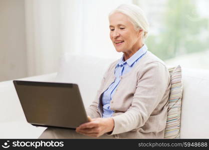 technology, age and people concept - happy senior woman with laptop computer at home