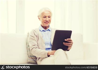 technology, age and people concept - happy senior woman with tablet pc computer at home