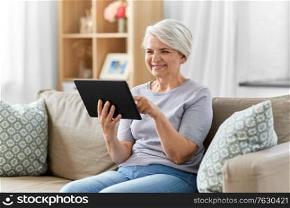technology, age and people concept - happy smiling senior woman with tablet pc computer at home. happy senior woman with tablet pc at home