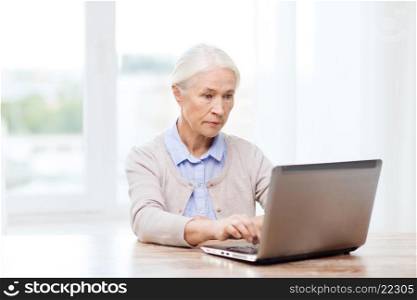 technology, age and people concept - senior woman with laptop computer at home