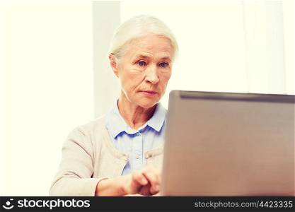 technology, age and people concept - senior woman with laptop computer at home