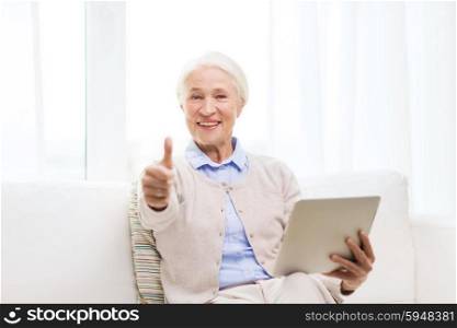 technology, age, gesture and people concept - happy senior woman with tablet pc computer showing thumbs up at home