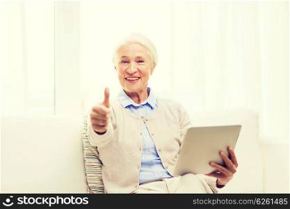 technology, age, gesture and people concept - happy senior woman with tablet pc computer showing thumbs up at home