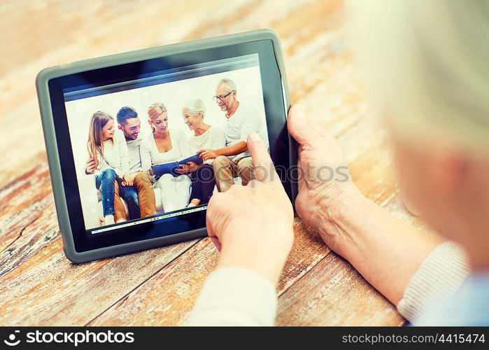 technology, age, memories and people concept - happy senior woman with tablet pc computer viewing family photo album at home