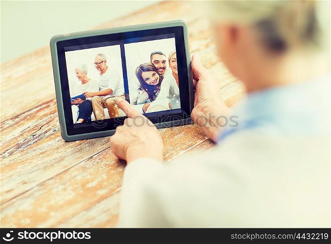 technology, age, memories and people concept - happy senior woman with tablet pc computer viewing family photo album at home