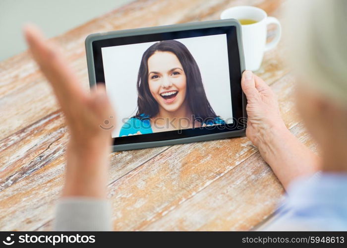 technology, age, memories and people concept - happy senior woman with tablet pc computer viewing photo or having video chat with granddaughter at home