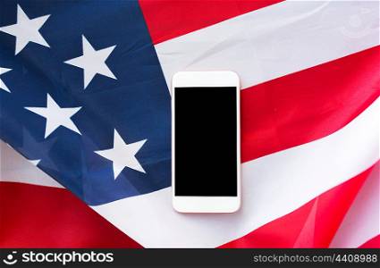 technology, american independence day, patriotism and nationalism concept - close up of smartphone with black blank screen on american flag