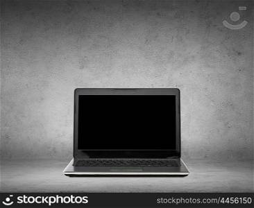 technology and advertisement concept - laptop computer with black blank screen over gray concrete background. laptop computer with black blank screen