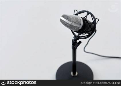 technology and audio equipment concept - close up of microphone on white background. close up of microphone on white background