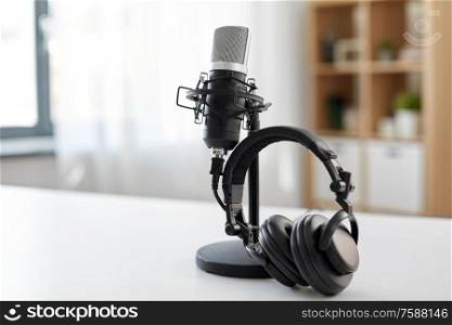 technology and audio equipment concept - headphones and microphone at home office or recording studio. headphones and microphone at home office