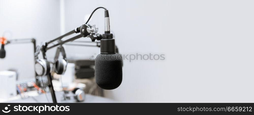 technology and audio equipment concept - microphone at recording studio or radio station. microphone at recording studio or radio station