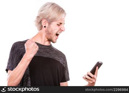 Technology and communication. Angry mad young man using mobile phone reading bad message, isolated on white. Angry man using mobile phone read message