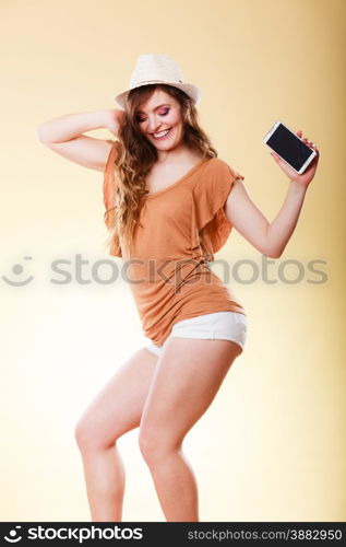 Technology and communication. Attractive summer woman using mobile phone holding smartphone dancing bright background