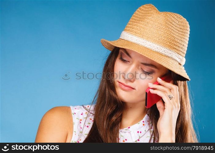 Technology and communication - confused teen girl talking on mobile phone smartphone, worried woman using cell phone on blue. Misunderstanding.