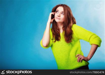 Technology and communication. Happy woman teenage girl talking on mobile phone, using smartphone on blue
