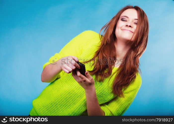 Technology and communication. Happy woman teenage girl texting on mobile phone, using smartphone reading sms message on blue