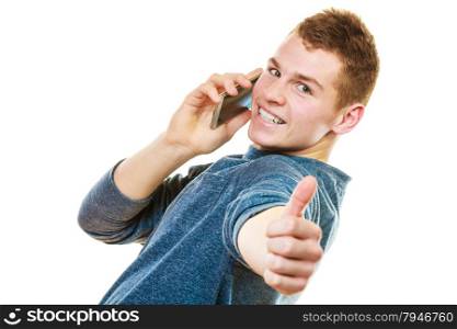 Technology and communication. Young man casual style talking on mobile cell phone using smartphone making thumb up hand sign gesture isolated on white