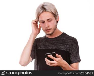 Technology and communication. Young man sad serious face expression using mobile phone reading bad message, isolated on white. Shocked man using mobile phone read message