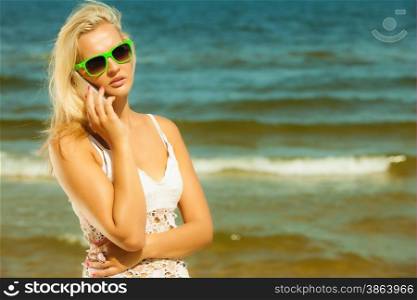 Technology and communication. Young woman pretty girl talking on mobile cell phone using smartphone on beach
