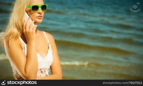Technology and communication. Young woman pretty girl talking on mobile cell phone using smartphone on beach