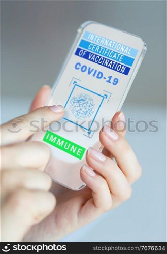 technology and health care concept - close up of hands holding and showing smartphone with international certificate of vaccination or virtual immunity passport on screen. hand holding phone with certificate of vaccination