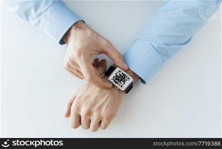 technology and health care concept - close up of man’s hands with qr code on smart watch at office. man’s hands with qr code on smart watch