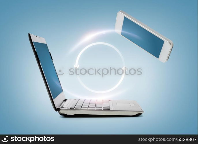 technology and internet concept - smartphone and laptop connecting