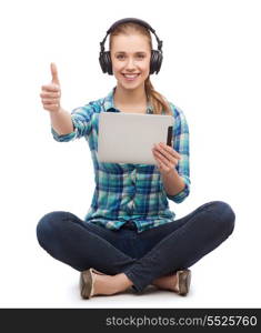 technology and internet concept - smiling young woman sitiing on floor with tablet pc computer and headphones and showing thumbs up
