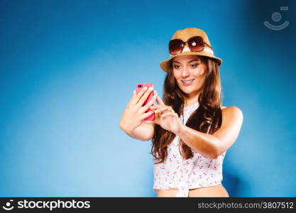 Technology and internet. Happy woman using cellphone texting on mobile phone. Teen girl reading sms on smartphone, taking selfie on blue