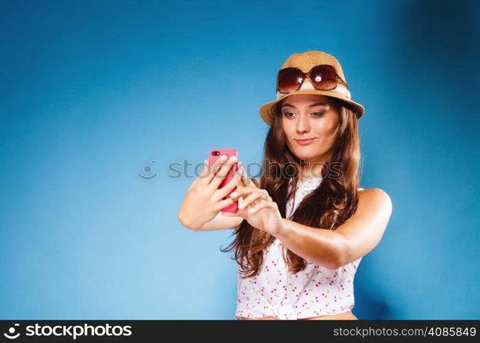 Technology and internet. Happy woman using cellphone texting on mobile phone. Teen girl reading sms on smartphone, taking selfie on blue
