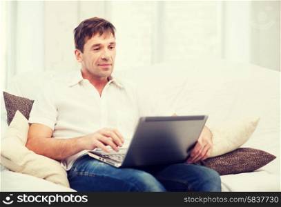 technology and lifestyle concept - man working with laptop at home