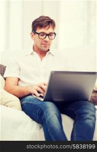 technology and lifestyle concept - man working with laptop at home