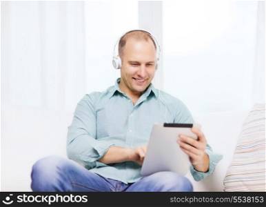 technology and lifestyle, distance learning concept - handsome man with tablet pc computer and headphones at home