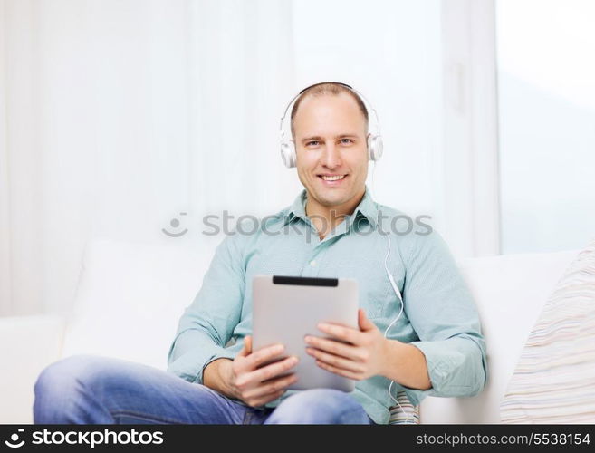 technology and lifestyle, distance learning concept - handsome man with tablet pc computer and headphones at home