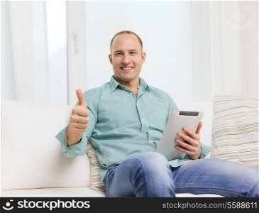 technology and lifestyle, distance learning concept - handsome man working with tablet pc at home and showing thumbs up