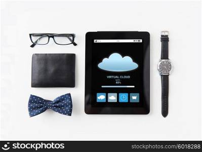 technology and objects concept - tablet pc computer with cloud computing process, wallet, eyeglasses, bowtie and wristwatch on table