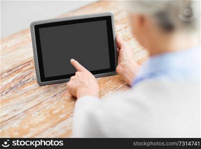 technology and old people concept - senior woman pointing finger to blank screen of tablet pc computer. senior woman with black screen on tablet computer