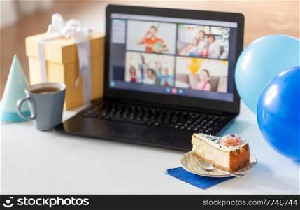 technology and online party concept - piece of birthday cake on plate and laptop computer with video call on screen at home. birthday cake and laptop with video call on screen