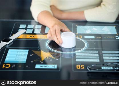 technology and people concept - close up of woman using rotary control knob on interactive panel with virtual data hologram. woman with control knob on interactive panel