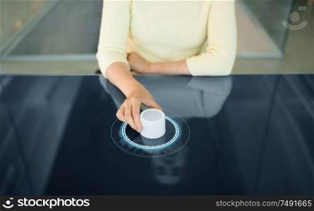technology and people concept - close up of woman using rotary control knob on interactive panel with virtual hologram. woman with control knob on interactive panel
