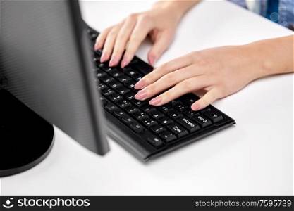 technology and people concept - female hands with red manicure typing on computer keyboard on table. female hands typing on computer keyboard
