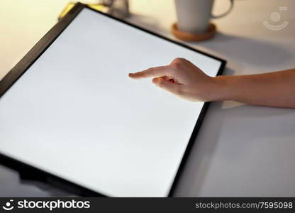 technology and people concept - hand on led light tablet or touch screen at night office. hand on led light tablet at night office